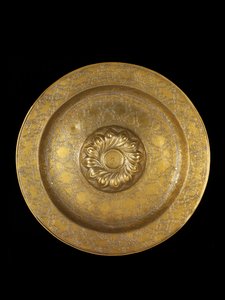 Dish of engraved brass with silver inlay, the central medallion encircled by repousse spiral gadroons, 1500-1525