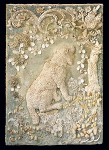 One of a pair of Louis XV seated dogs modelled in relief, within a grotto-like surround by German School