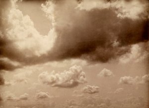 Stretch of Sky with Large Clouds. The Silhouette of the Hills Can Be Made Out Below