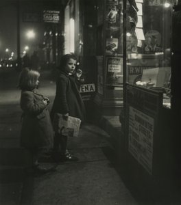 Two Little Girls in Winter Coats Standing Outside a Shop at Night by Godfrey Macdominic