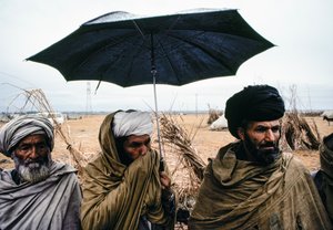 Pakistani Men with an Umbrella and Traditional Garments