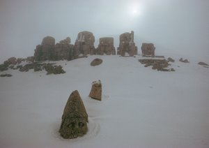Statue of a god peers above a blanket of snow at Nemrud Dagh. Nemrud Dagh, Turkey. by James L Stanfield