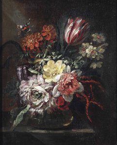 A tulip, roses, daffodils and other flowers in a glass vase, a butterfly above, all on a partially draped table