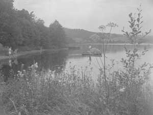 Man fishing in a boat on Esthwaite Water and two girls at the water
