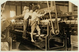 Small boys climbing on spinning frame to mend broken threads and replace empty bobbins at Bibb Mill, Macon, Georgia, 1909 by Lewis Wickes Hine