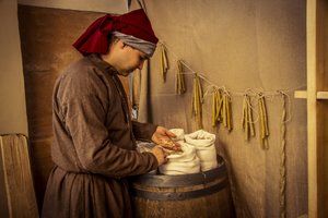 Historical reenactment: Candles and sacks of wheat, rye and barley in the apothecary of Diotaiuti, Imola, Italy, mid-14th century