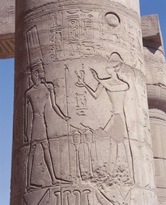 Relief of pharaoh holding goddess of justice Maat before Amon on pillar