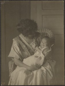 Florence Holding Baby in Rocking Chair by Louis Fleckenstein