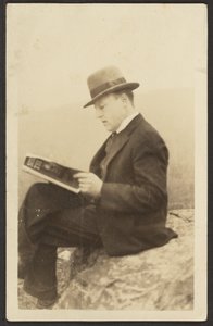 Man Reading Magazine on Rock