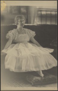 Woman in Chiffon Dress Seated on Sofa by Louis Fleckenstein