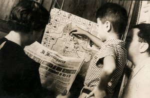 A Woman Reads the Front Page of The Messenger with the Title 
