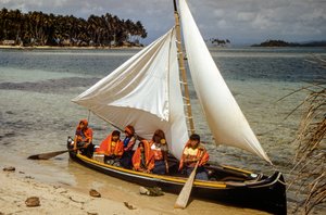 Women with gold nose rings of Cuna tribe of Mulatas aka San Blas Islands paddle and sail