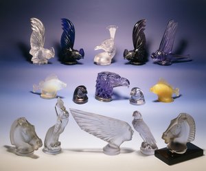 Various glass car mascots (of birds, fish, horses and a human head)