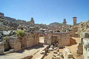 View through the vaulted entrance of the Xanthos theatre into the Orchestra pit, showing pillar and Harpy tomb, Xanthos, Turkey