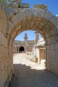 View through the vaulted entrance of the Xanthos theatre into the Orchestra pit, showing pillar and Harpy tomb, Xanthos, Turkey by Roman