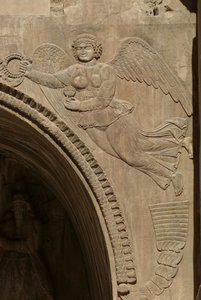 Genius holding a bowl of fruit, symbolising plenty, from a spandrel of an aivans, 590-628 by Sasanian School