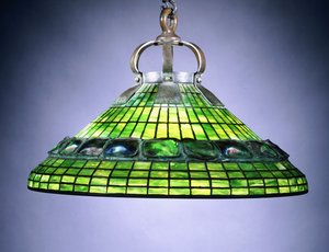 A leaded glass turtleback tile and bronze chandelier by School American
