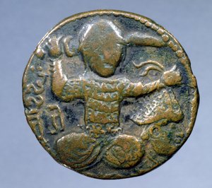 Obverse of Coin Depicting Helmeted Turk Sitting Cross-Legged Holding a Sword Behind His Head in Right Hand and a Helmeted Severed Head in Left Hand, Minted by Husam al-Din Yuluq Arslan (1184-1201)