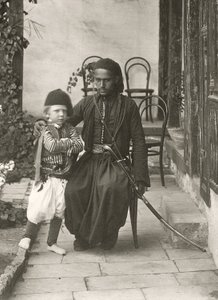 Arab kawass (Ottoman guard) with a young boy in the garden of a house in the Judea District of Jerusalem