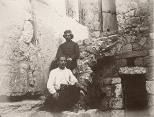 Two men sitting next to the lintel of Barclay