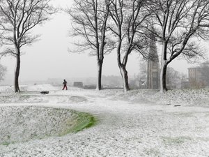 Lone figure walking in Copenhagen Fortress during snowstorm, Denmark, 2022 by Sisse Brimberg