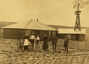 Family of Homesteaders, Outside of Their Sod House with a Windmill on the Roof of the Adjoining Building in Custer County, Nebraska