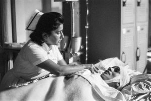 Nurse aids a patient on stretcher after surgery on hospital ship SS Hope