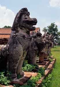 Lion-like stone guardian figures built around the base of the stupa by Thai School