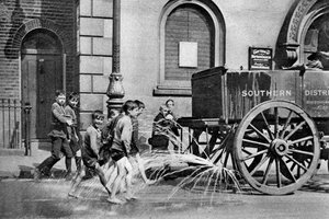 Boys following the Poplar Borough Council water cart, London, 1926-1927
