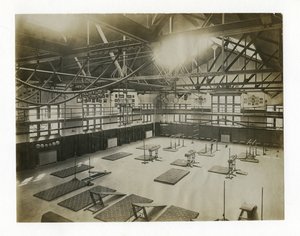 Horizontal Photograph of the Interior of a Large Gym. Equipment and Mats are Spread Out on the Floor by Unbekannt