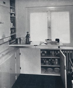 Kitchen with a black Dutch tiled floor, white walls and built-in shelves and cupboards