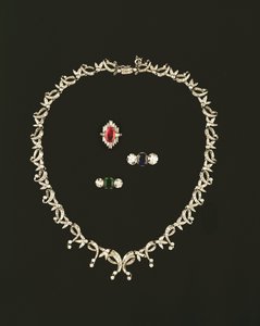 Art Deco scroll and leaf design necklace; ruby and diamond baguette cluster ring; sapphire and diamond three stone ring; emerald and diamond three stone ring