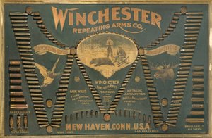 A Winchester Cartridge display board, with a comprehensive selection of metallic, brass and paper-case rifle and shot cartridges arranged in the form of an extended 