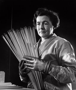 A female employee with rods of carbon electrodes used by arc welders by Unbekannt