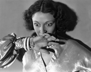 Hollywood, California: c.1932 Close-up of a young woman covering her mouth in fright