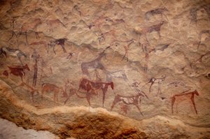 Rock art, Prehistory: Rock painting of a group of cattle and polychrome characters (shepherds and archers) in an ornate shelter, in the Uweinat massif, Sudan. Period from 8000 to 3000 years BC. Photography by Unbekannt