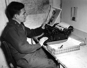Second World War: Mutzig, France, 1 December 1944: Corporal Flanerty chronicler of the Beachead News looks at a pin-up photograph that he publishes in the next issue of the newspaper by Unbekannt