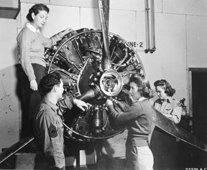 Wasps learn where the power comes from in the B-17 Flying Fortress engine while attending B-17 pilot training at Lockbourne AAB, Working on the propeller mechanism, while a crew chief looks on, they are Patricia Bowser, Ann Waldner and Frances Green