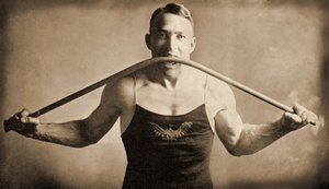 Californian Strongman Mr. P. A. Linebarger bends an iron bar with his teeth, San Francisco c.1922