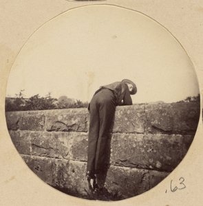 Man in Hat Bent Over a Stone Wall by Unknown artist