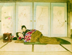 Reclining on a Futon. Two Japanese Women Recline on a Traditional Futon Placed on the Floor. Japan, circa 1910.