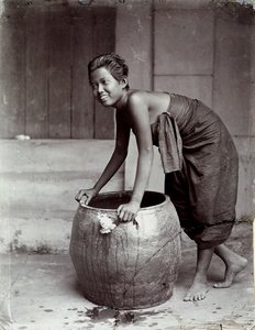 Young smiling Thai woman, pushing a large container