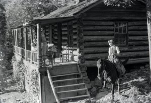 Woman, possible healthcare worker, on horseback visits with neighbors or family