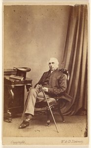 Unidentified White-Haired Man Seated, Holding a Cane, Top Hat and Book on Table at Left by W. and D. Downey