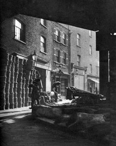 Fruit baskets piled against houses at Borough Market, London, 1926-1927