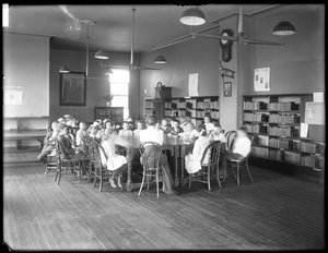 Children listen to a woman in the reading room of an unidentified branch of the Queens Borough Public Library, c.1910 by William Davis Hassler