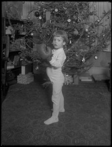 Unidentified Child Standing in Front of a Christmas Tree Wearing Boxing Gloves, 1915-16