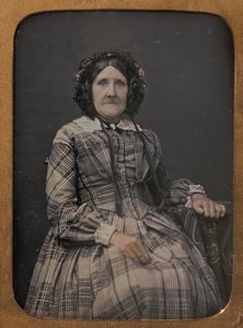 Seated Elderly Woman Wearing Plaid Dress and Bonnet
