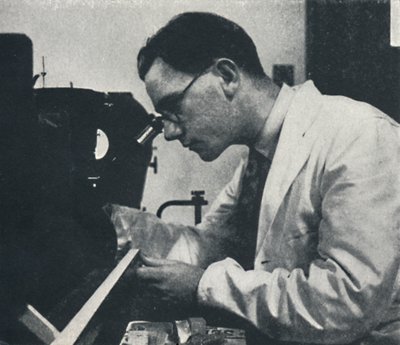 Research worker with microscope testing the structure of an aluminium alloy, 1941 by Cecil Beaton