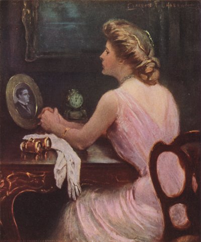 Woman Sitting at Her Dressing Table Looking at a Photograph of a Man by Clarence F. Underwood